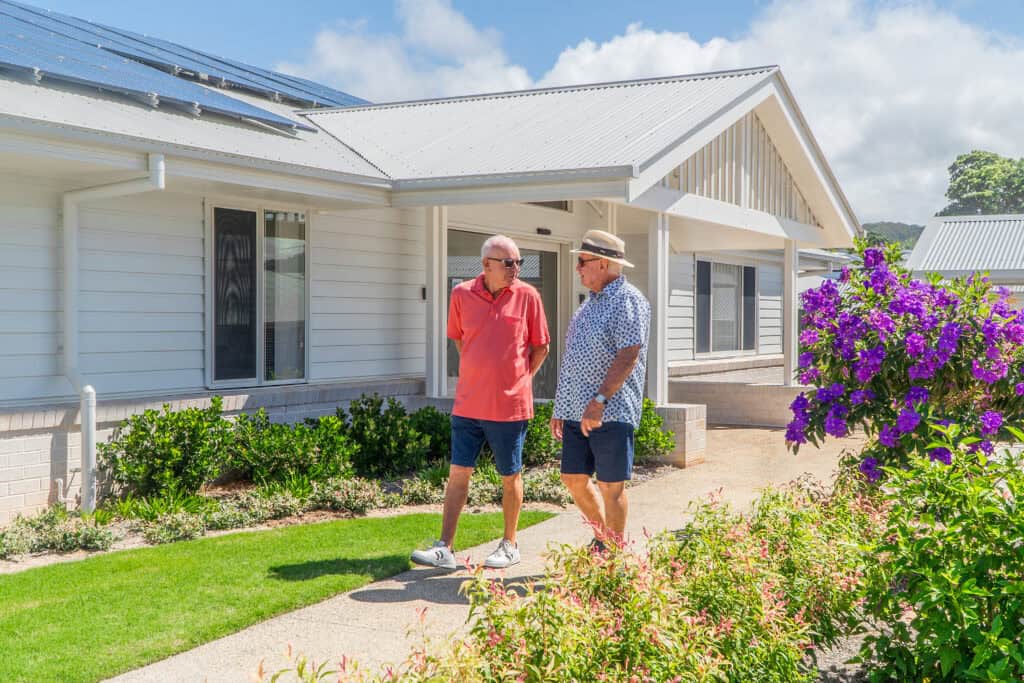 Two senior men walking around a retirement village